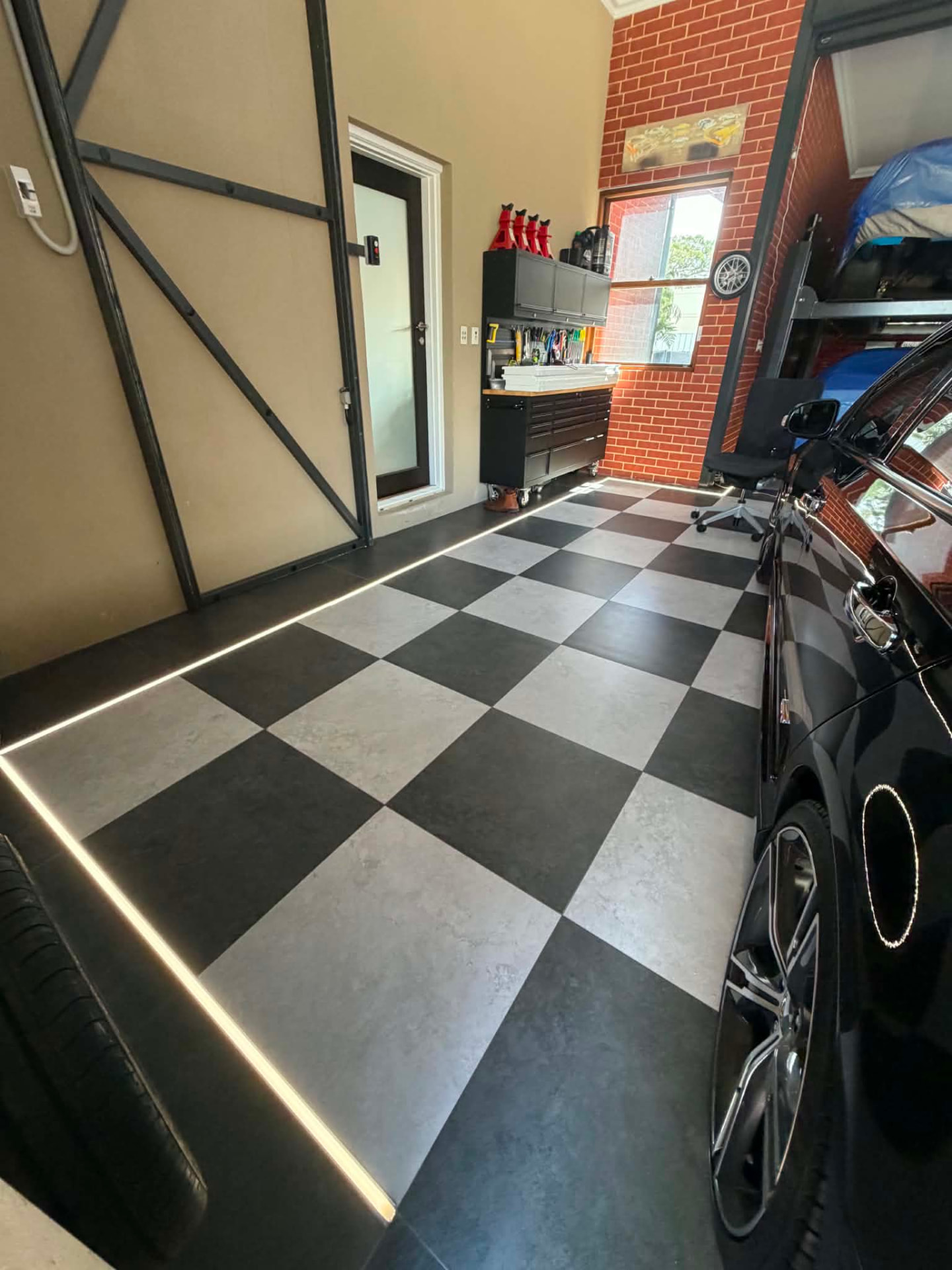 Garage with checkerboard floor and LED strip lighting