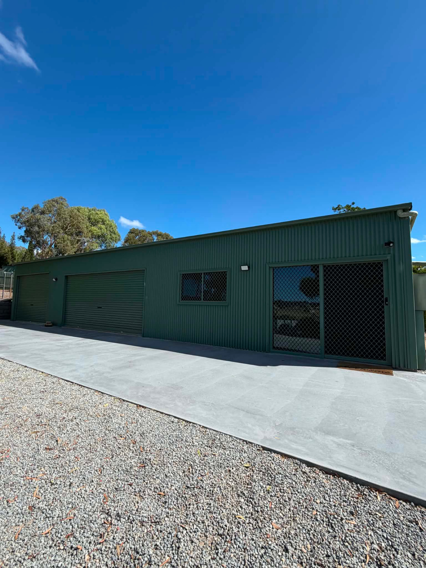 Green colorbond shed with roller doors and external lighting