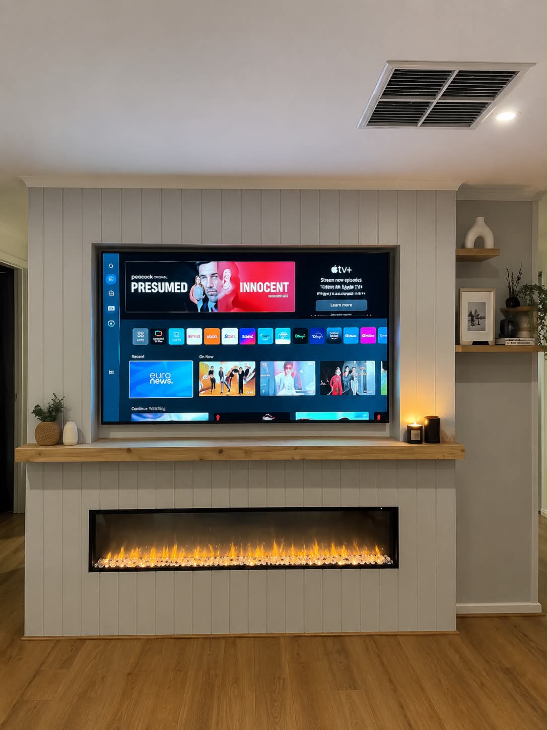 Wall-mounted TV above a linear fireplace with concealed cabling
