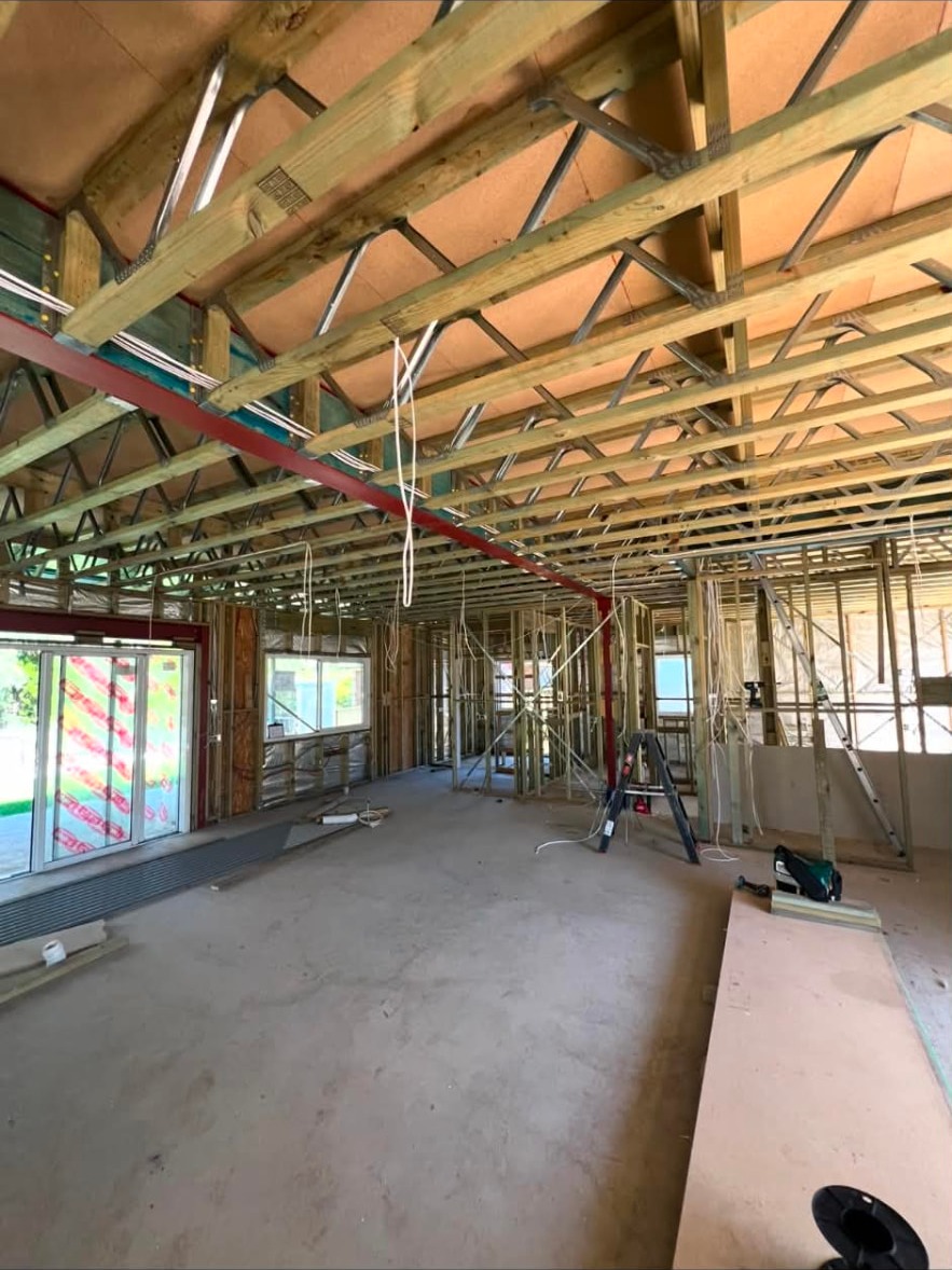 Timber-framed home during electrical rough-in with cabling run through trusses