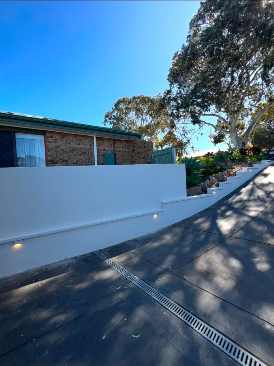 Rendered retaining wall with recessed LED step lights along a driveway